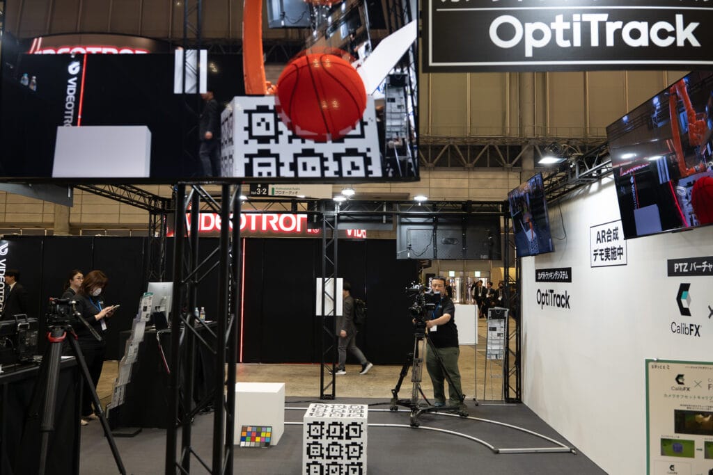 マーカーの書かれた箱を取るカメラと、モニター上で仮想的にバレーボールが合成されている様子