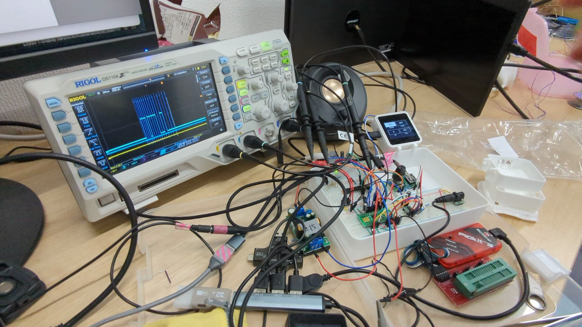 オーディオ機器の制御基板と計測器を接続して調整している様子